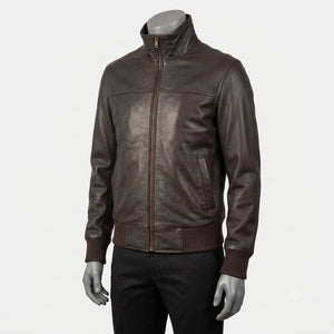 A dark brown leather jacket with a stand-up collar and front zipper, displayed on a gray mannequin torso against a light gray background.